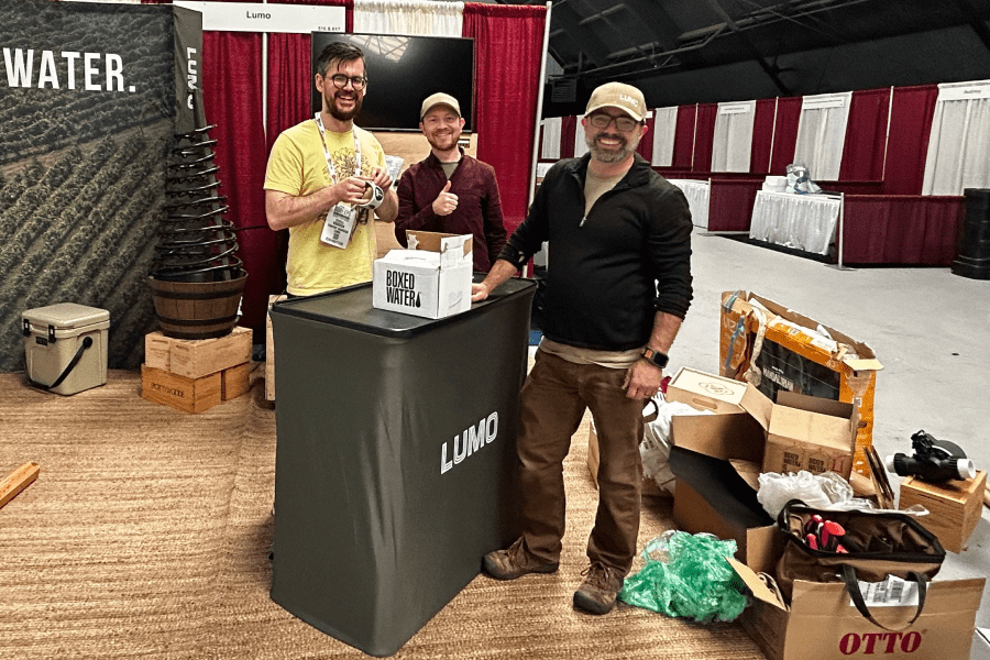 Lumo content manager, Steele Roddick setting up tradeshow booth with Josh Zoland and Marc Krafft