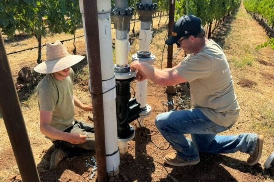 Andy installing four inch smart valve in a vineyard