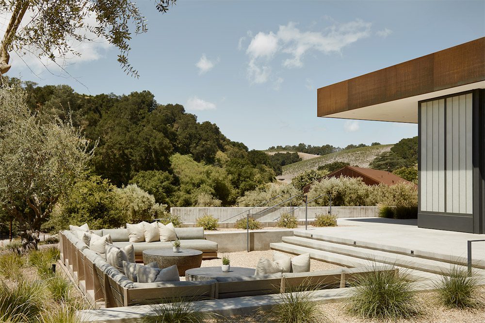 The terrace at Booker Wines, with lounge seating and vineyard hills behind